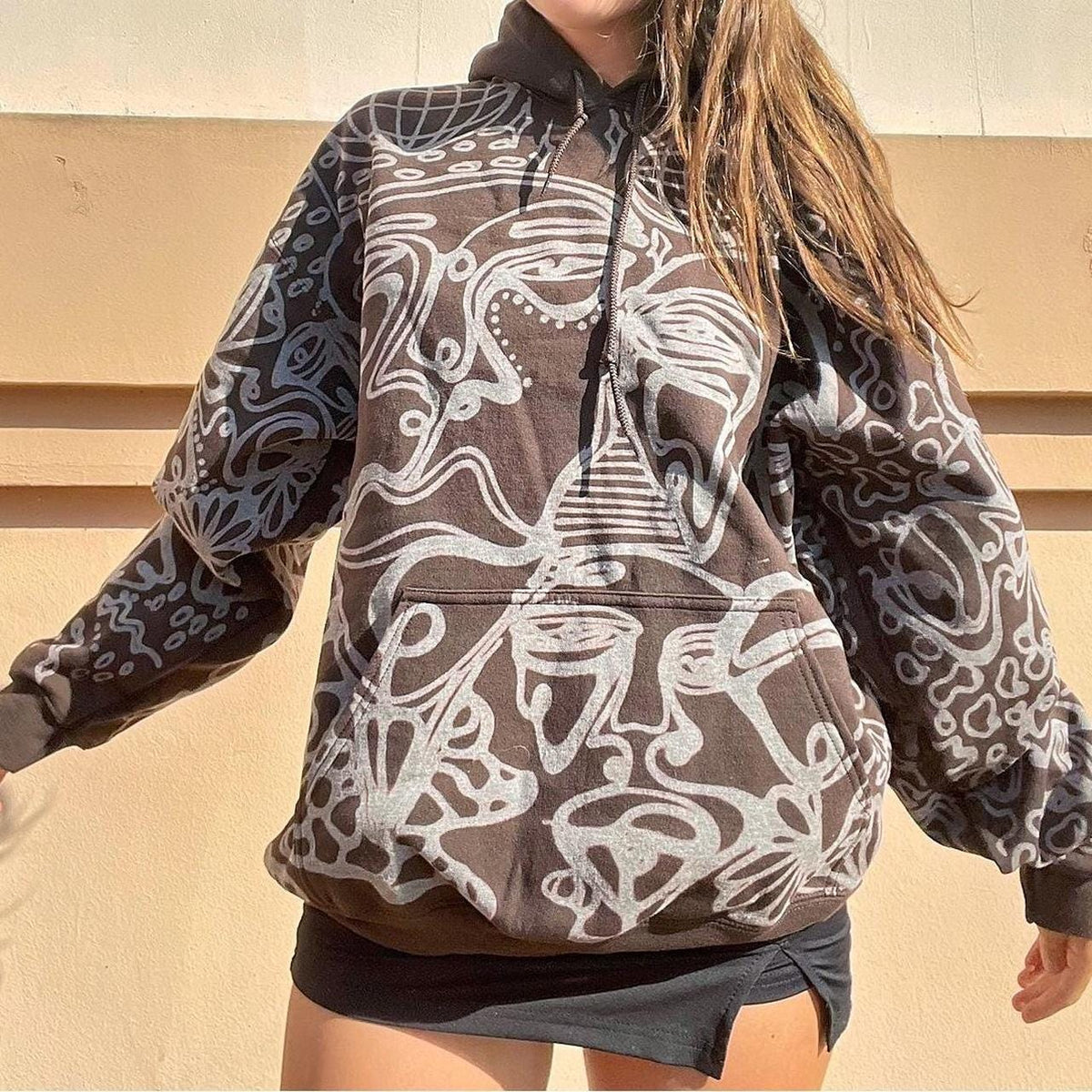 .Abstract faces, spotted mushroom clouds, and geometric cozy hoodie in dark chocolate brown and cream