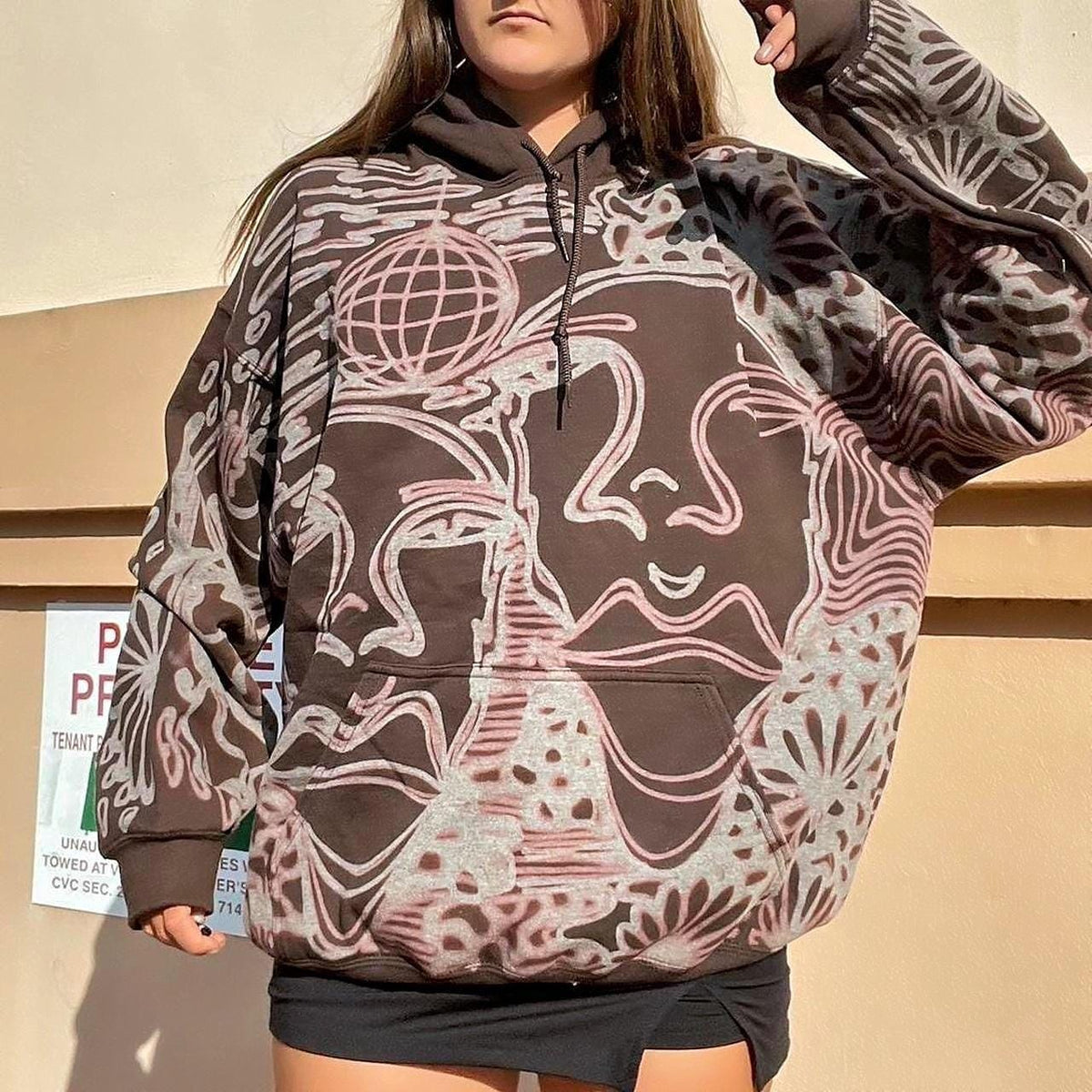 Abstract faces, floral pattern, and geometric style hoodie in dark chocolate brown and cream